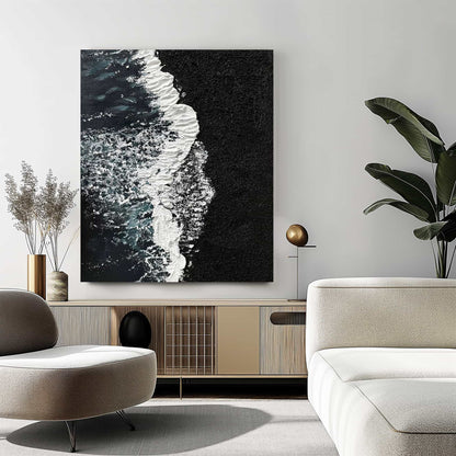 "BLACK BEACH, STYLE B: Hand-painted Portrait shaped and Landscape shaped textured wall art painting depicting a black beach with crashing waves, hanging in the lounge, in shades of black, white, blue, green and grey."